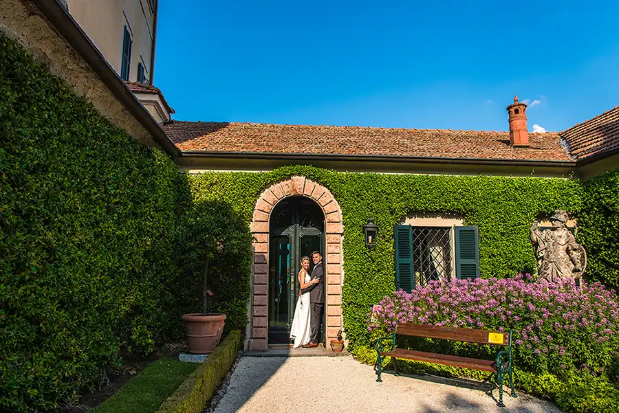 Bride and groom standing in the doorway of an ivy-covered villa during a wedding on Lake Como.