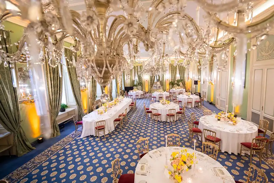 Elegant reception room at Villa d’Este set for a wedding on Lake Como with chandeliers and round tables.