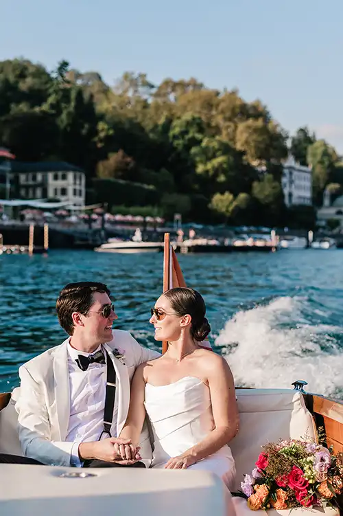 Bride and groom on a wooden boat on Lake Como during a luxury wedding in Italy.