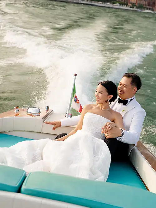 Bride and groom on a classic Venetian boat during a luxury wedding on Lake Como