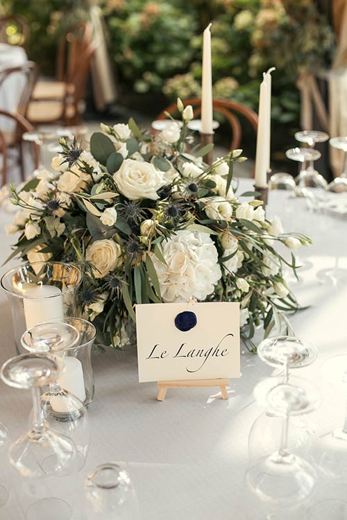Centerpieces with olive leaves, white flowers and lot of country greenery