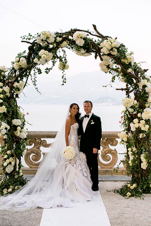 The majestic floral arch made by branches, ivy and bunches of white roses and peonies.