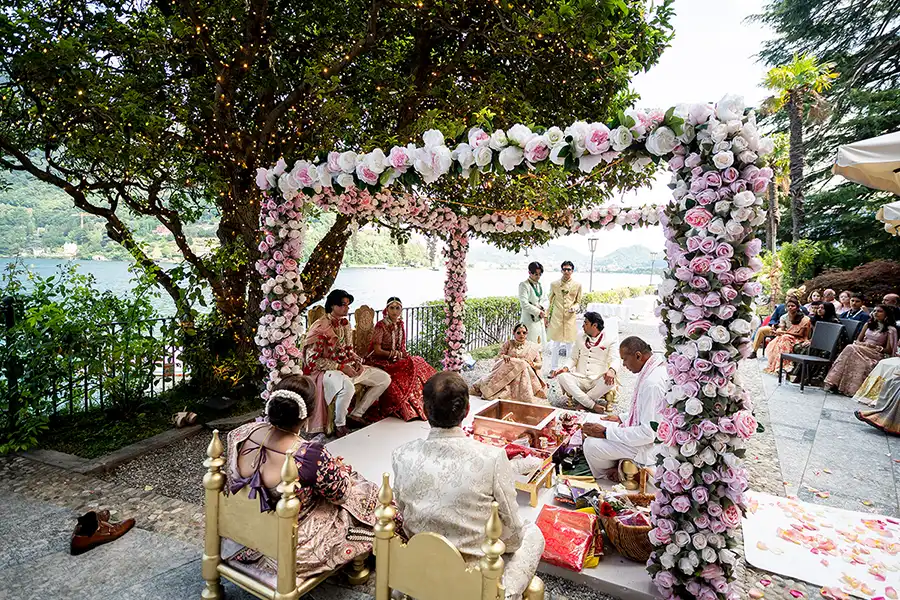 A colourful Indian wedding ceremony on Lake Como with an extraordinary floral mandap by the water.