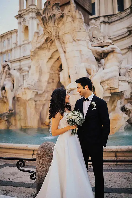 Bride and groom in front of an iconic fountain di Trevi in Rome during an elegant wedding portrait session.