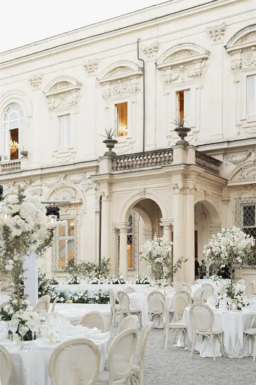 Outdoor wedding reception setup at a historic villa Miani in Rome with white floral arrangements.