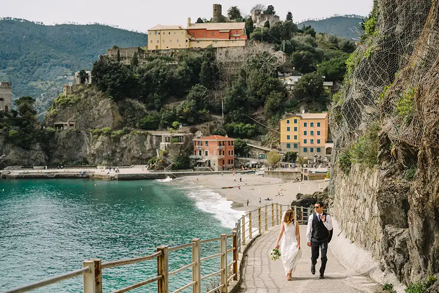 Bride and groom walking along the Via dell’Amore in Cinque Terre during a wedding on the Italian Riviera