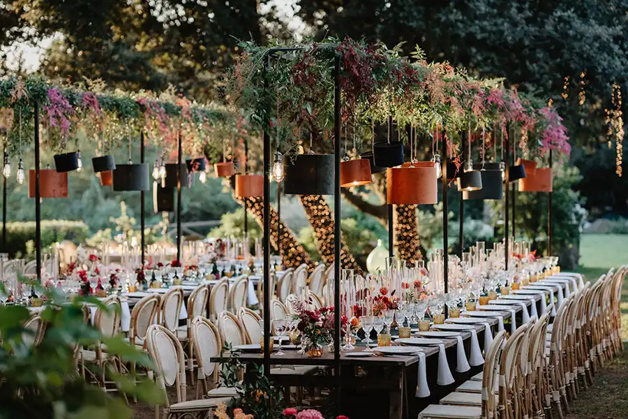 Elegant outdoor wedding reception with long tables and hanging floral arrangements on the Italian Riviera