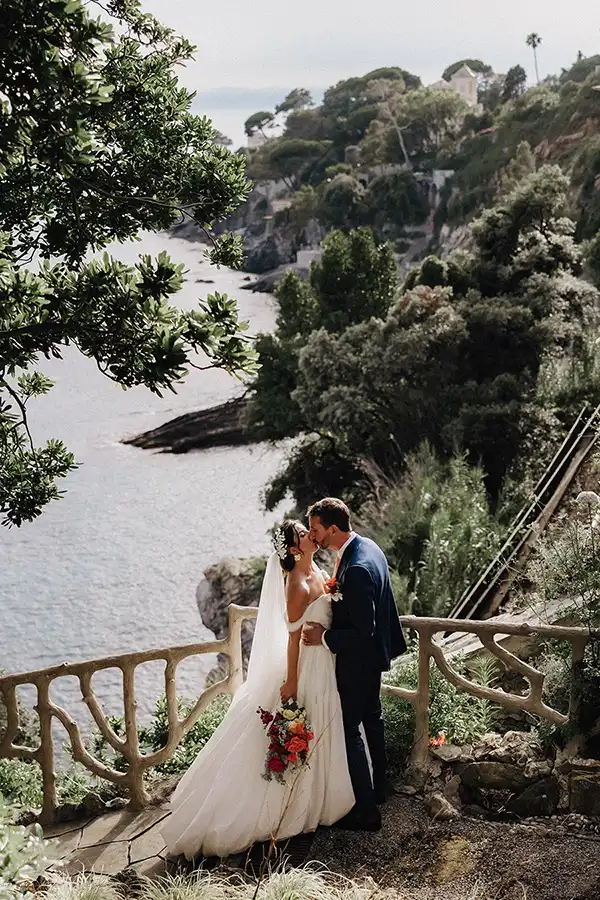 Bride and groom kissing on a sea view terrace during a wedding on the Italian Riviera