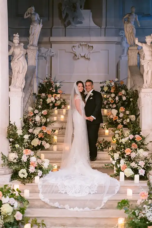 Bride and groom on a grand floral staircase during a wedding on Lake Garda