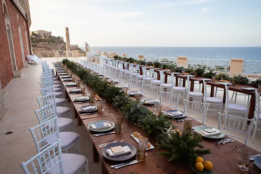 Elegant wedding reception terrace in Sicily with long tables and sea view
