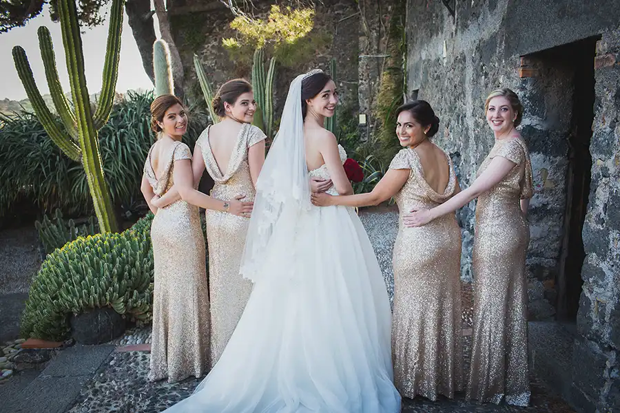 Bride with bridesmaids in gold dresses surrounded by cactus garden at a Sicily wedding venue