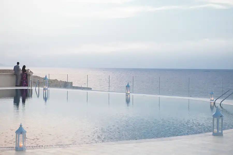 Infinity pool overlooking the sea at a wedding venue in Sicily at sunset