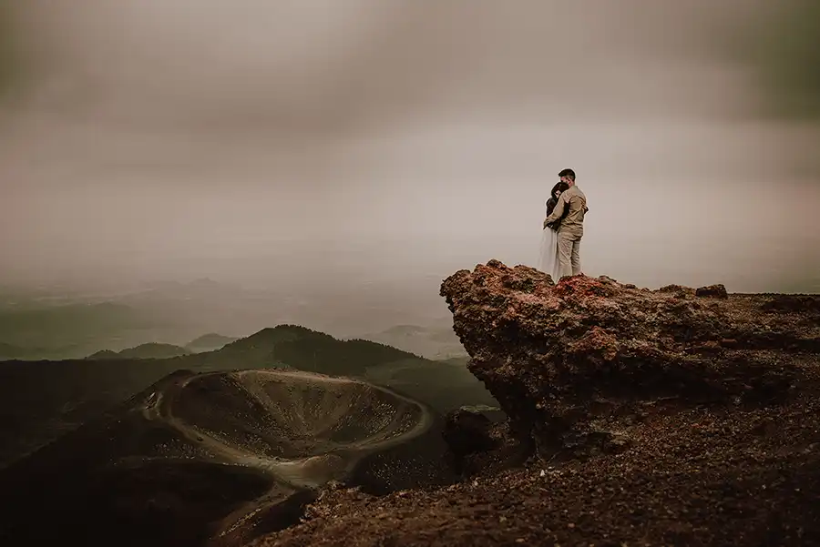 Engaged couple on top of Mount Etna in front of a volcanic crater in Sicily