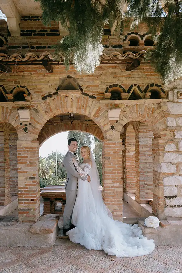 Bride and groom beneath a historic stone arch during their wedding in Sicily
