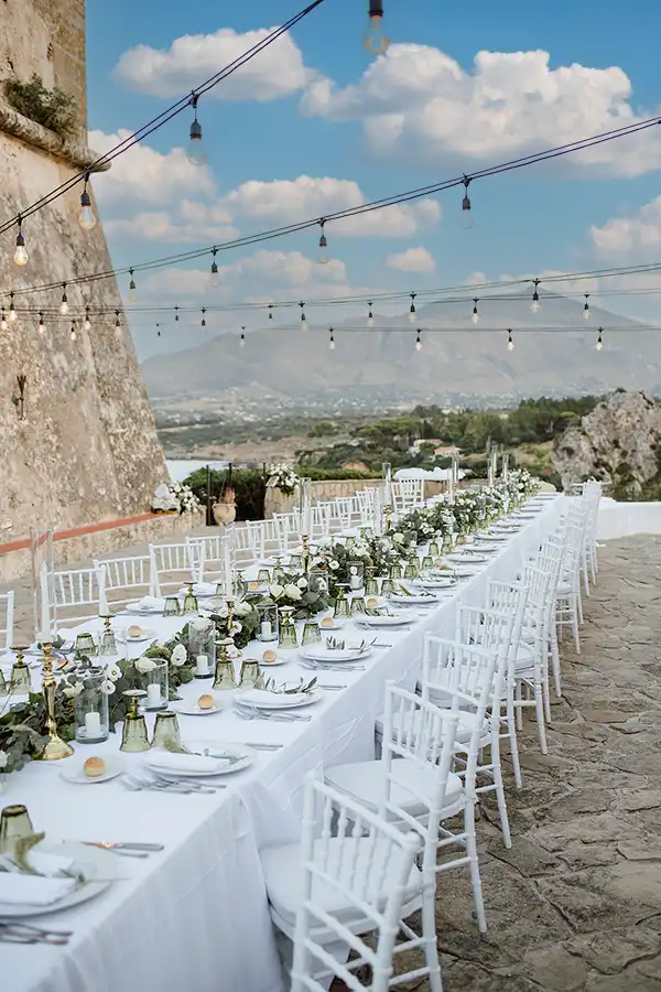 Elegant wedding reception table set outdoors with mountain views in Sicily