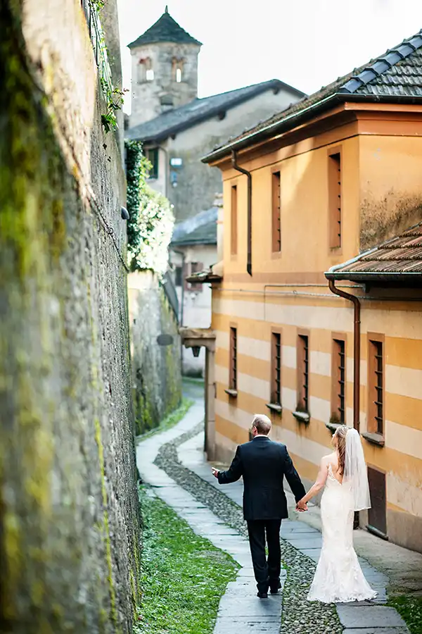 Bride and groom walking through the historic streets of Orta San Giulio