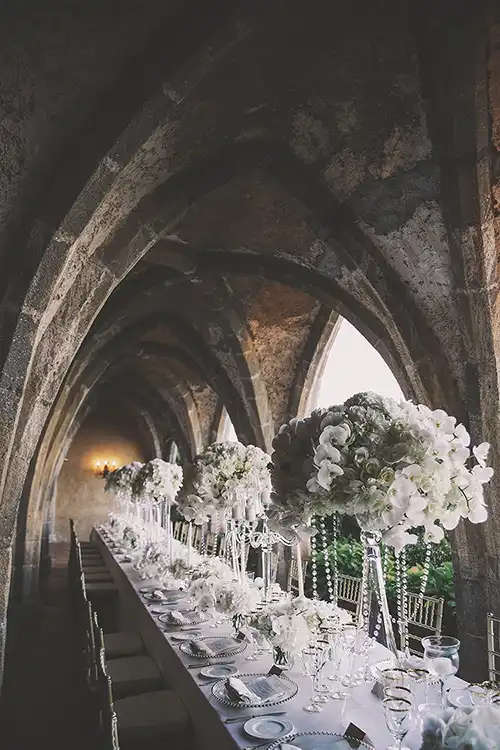 Elegant wedding reception table with white flowers in a historic Amalfi Coast venue